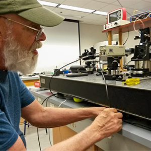 Instructor fine-tuning a flow cytometer optical bench at Los Alamos, 1993